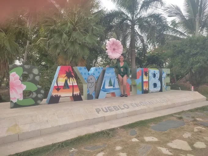 Viajera posando frente al letrero de Bayahibe, Pueblo Encantado, República Dominicana