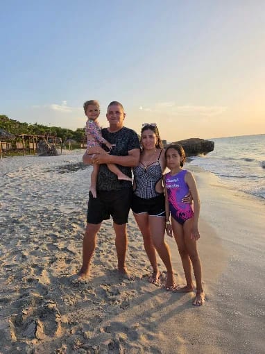 Familia de cuatro personas en la playa al atardecer