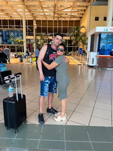 Pareja reencontrándose en el aeropuerto con maleta